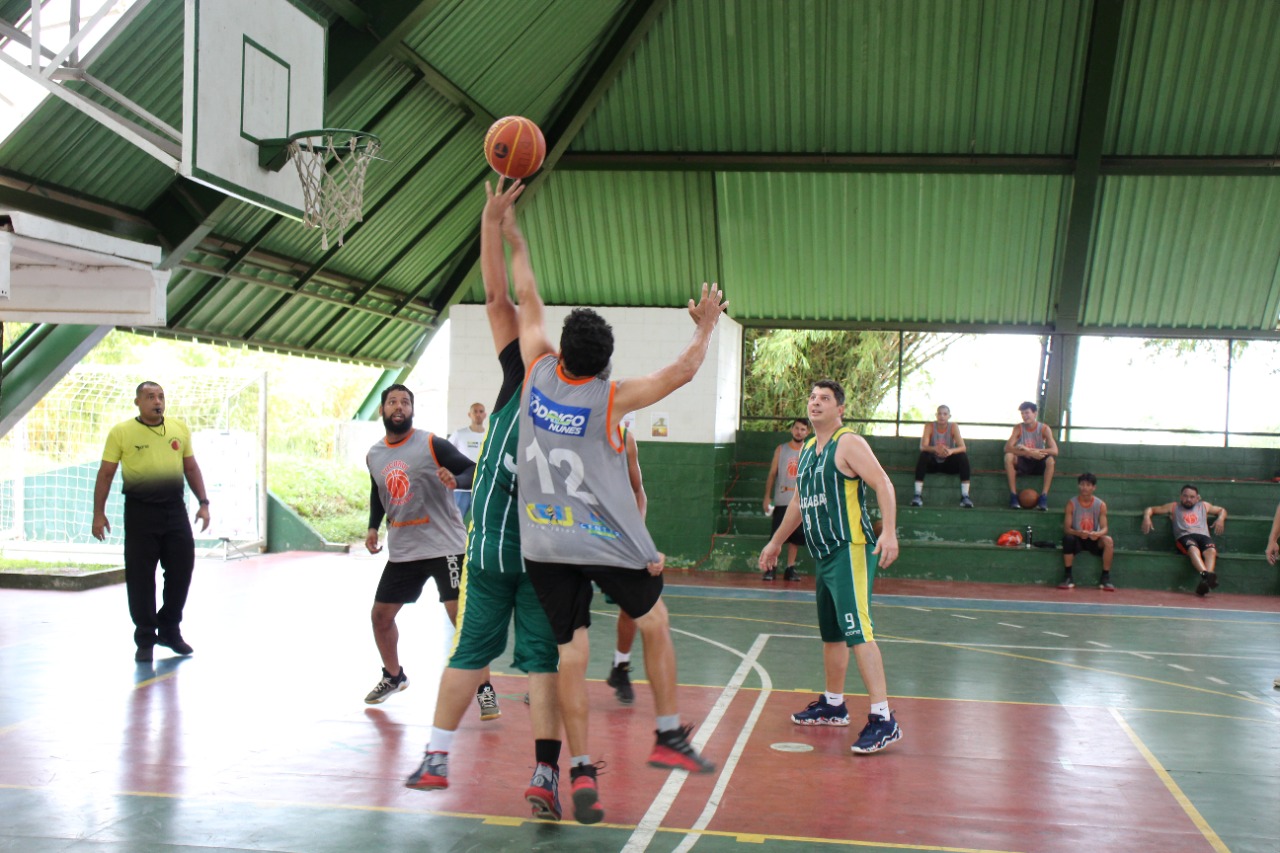 Pessoas jogando basquete em quadra poliesportiva pública na orla